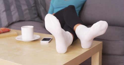 woman resting her feet on a coffee table, close-up of socks/feet