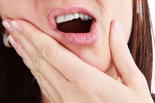 close-up of mouth, woman experiencing tooth pain 